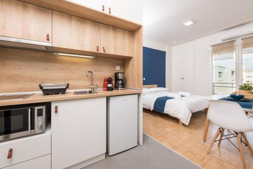 a kitchen and bedroom with a bed in the background at Pantheon square view 3 in Komotini