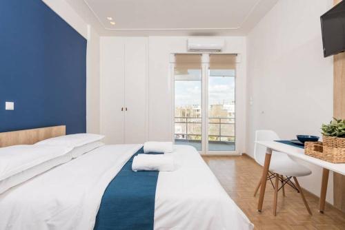 a bedroom with a bed and a desk and a window at Pantheon spuare view 3 in Komotini