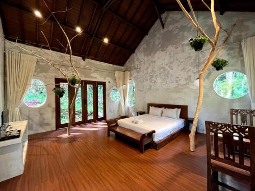 a bedroom with a bed and a tree in it at Imah Seniman in Lembang