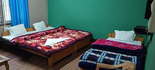 1 dormitorio con 2 camas y papel blanco en Aajanta, en Tawang