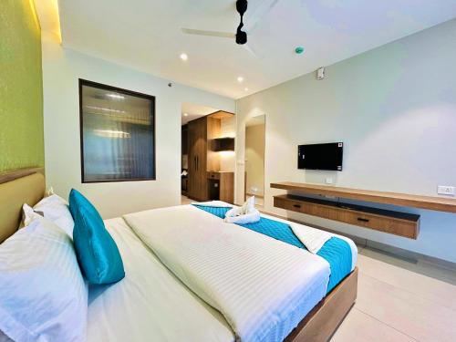 a bedroom with a large bed and a flat screen tv at VAGA NAKSHATHRA SUITES in Vagamon