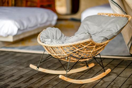 a rocking chair with skis on a room with a bed at Grow Tree Glamping in Dahu