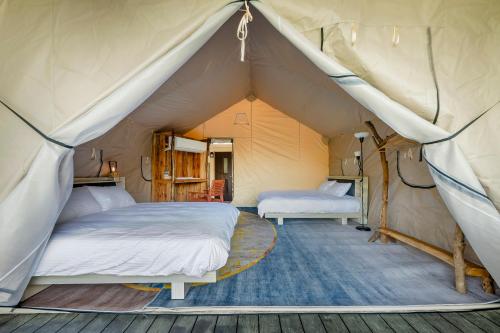 a bedroom with two beds in a tent at Grow Tree Glamping in Dahu