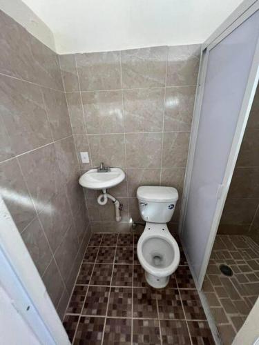 a small bathroom with a toilet and a sink at Departamento Carnaval in Autlán de Navarro