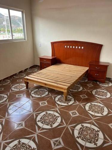 a room with a wooden bench on a tile floor at Departamento Carnaval in Autlán de Navarro