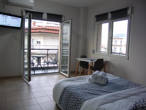 1 dormitorio con cama y vistas a un balcón en Kapsouli spuare 2, en Komotiní