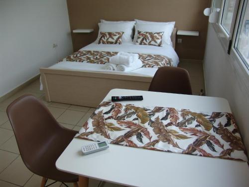 a room with two beds and a table and chairs at Kapsouli square 2 in Komotini