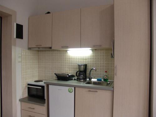 a small kitchen with a sink and a microwave at Kapsouli square 2 in Komotini