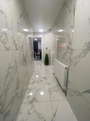 un bagno con pareti in marmo e un corridoio in marmo. di THE ROYAL BOUTIQUE OXFORD LODGE by LONDON SLEEP 8 a Hayes