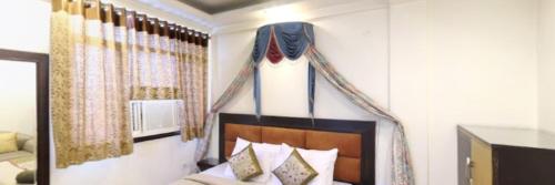 a bedroom with a bed with a head board at Hotel Yadu Residency Meerut in Meerut