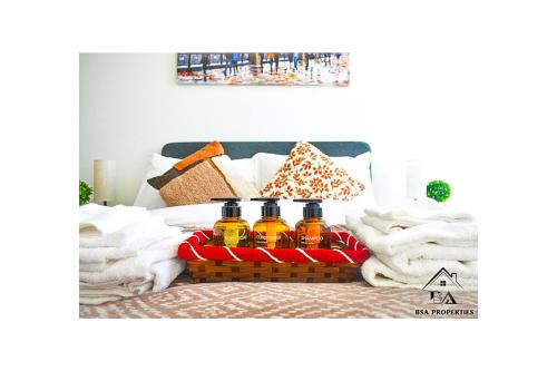 a basket of essential oils on a bed at City Centre Apartment Close to Ascot & Legoland Sleep Upto 4 Guests - Parking on Request! in Bracknell