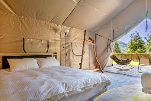 a bedroom in a tent with a bed and a patio at Grow Tree Glamping in Dahu