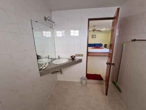 a bathroom with a sink and a mirror at Villa Oranje Chiang Mai in Chiang Mai