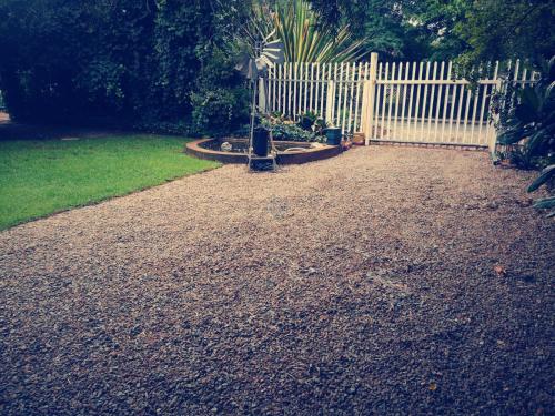 a garden with a white picket fence and a yard at Be Our Guest Near OR TAMBO International Airport in Boksburg