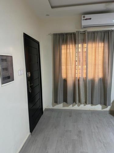 a room with a black door and a window at Keeluxe - Superbe appartement - Cite Keur Gorgui in Dakar