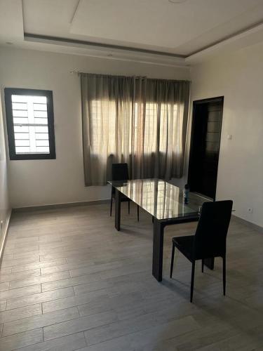 a dining room with a glass table and chairs at Keeluxe - Superbe appartement - Cite Keur Gorgui in Dakar