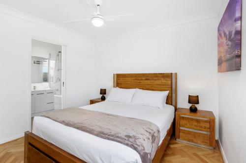 a bedroom with a large white bed and a mirror at Nautica Residences Hillarys in Perth