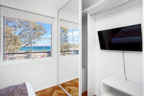 a white room with two windows and a flat screen tv at Nautica Residences Hillarys in Perth