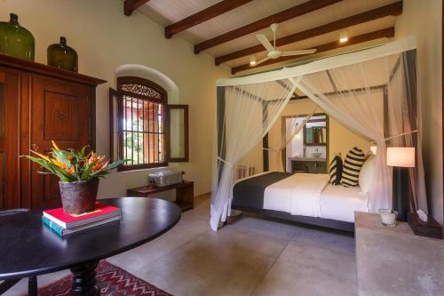 a bedroom with a bed and a table in a room at MO River House Luxury Villa in Hikkaduwa
