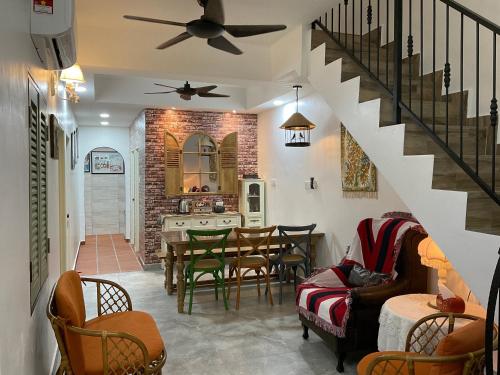 a living room with a staircase and a table and chairs at Jessie Home in Bukit Mertajam
