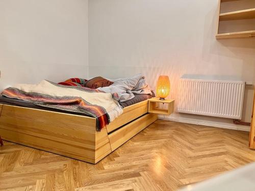 a bedroom with a bed with a lamp on a wooden floor at Cozy designer apartment in Friedrichshain in Berlin