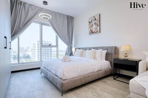 a bedroom with a large bed and a large window at Cosy Studio in Skycourts Tower in Dubai