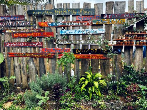 a wooden fence with many signs on it at Người Măng Đen Homestay in Kon Von Kla