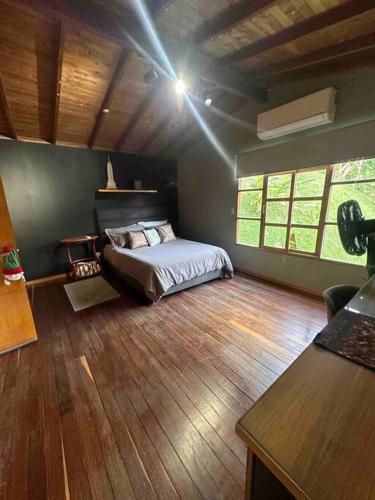 a bedroom with a bed and a wooden floor at Cabaña sendero verde in Envigado