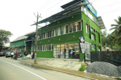 zielony budynek po stronie ulicy w obiekcie Aroma Inn Kerala w mieście Kalpatta