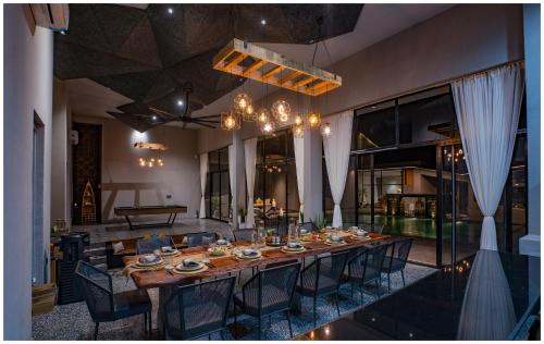 Un comedor con una mesa larga y sillas. en Casa Concreto- 5-Bedroom Luxury Villa with all weather Pool, en Jodhpur