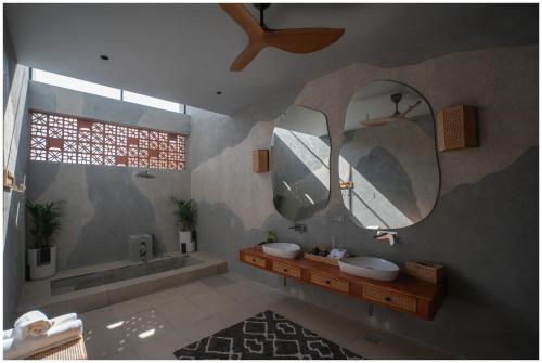 a bathroom with two sinks and a tub and mirrors at Casa Concreto-Infinite Luxury in Jodhpur