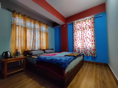 a bedroom with blue and red walls and a bed at Hotel Paramount in Dentam