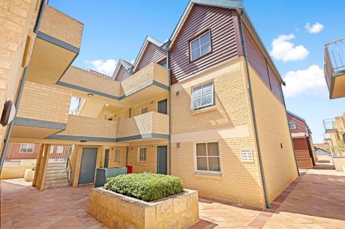 a large brick building with a staircase on it at Nautica Residences Hillarys in Perth