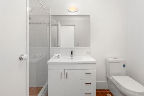 a white bathroom with a sink and a toilet at Nautica Residences Hillarys in Perth
