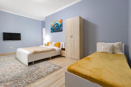 a small bedroom with two beds and a tv at Апартаменты Expo Residents со всеми удобствами in Astana