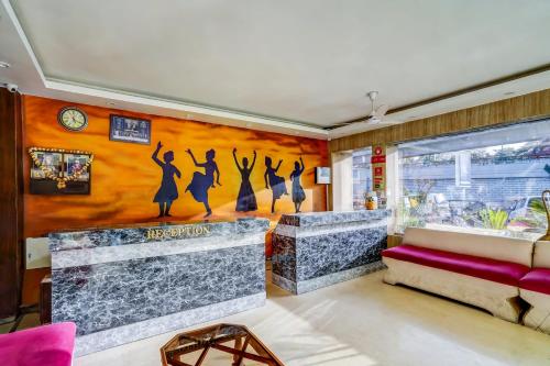 a living room with a wall with a mural of dancers at Hotel Jp Tower in New Delhi