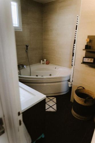 une salle de bain avec une baignoire blanche et un lavabo dans l'établissement Maison avec jardin tropical à 5 minutes de la Croisette, à Cannes