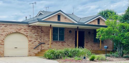 a brick house with a garage at Stylish 4 Bedroom Urban Retreat in Wagga Wagga