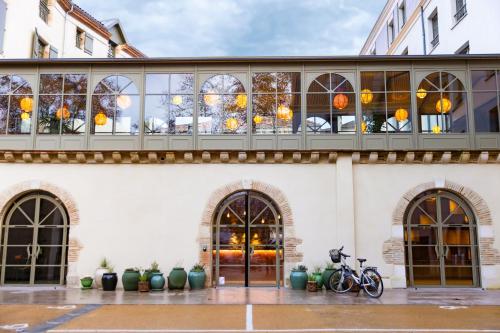 two bikes parked in front of a building with windows at Serra Boutique Hôtel in Agen
