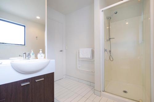 een badkamer met een wastafel en een douche bij Aqua Soleil Beachfront Apartment in Whitianga