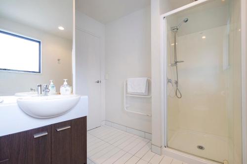a bathroom with a sink and a shower at Aqua Soleil Beachfront Apartment in Whitianga