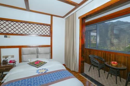 a bedroom with a bed and a table and a window at Zhangjiajie Mountainside in Zhangjiajie