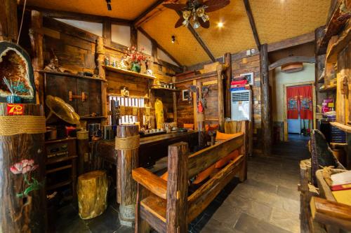 un ristorante con pareti in legno e un bar con panchine di Butterfly Flowers Inn a Zhangjiajie
