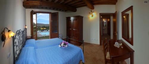 - une chambre avec un lit bleu orné de fleurs dans l'établissement Agriturismo Il Noce, à Orciatico
