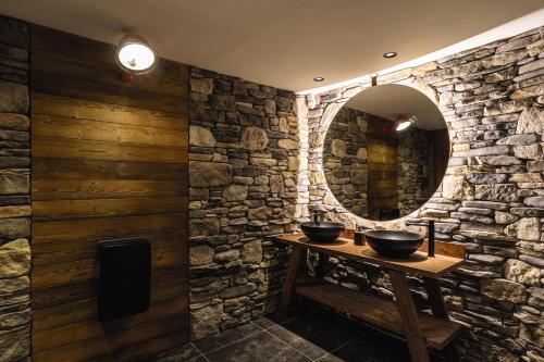 a stone bathroom with two sinks and a mirror at Belambra Clubs Tignes Val Claret in Tignes