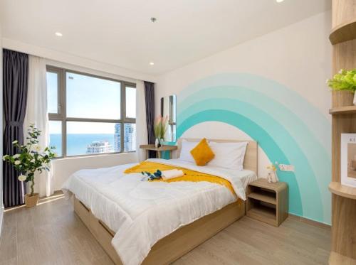 ein Schlafzimmer mit einem Bett mit einem an der Wand gemalten Regenbogen in der Unterkunft CONDOTEL 5 SAO THE SÓNG VŨNG TÀU Mr VƯƠNG in Vũng Tàu