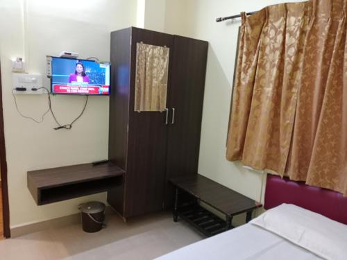 a room with a tv and a bed and a tvictericter at HOTEL SUNANDA LODGE in Belgaum