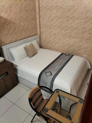 a small room with a bed and a chair at Roma Hotel Noi Bai airport in Hanoi