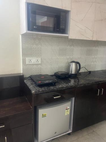 una cucina con piano cottura e forno a microonde di Paramount studio near pari chowk a Greater Noida
