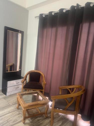 una stanza con due sedie, un tavolo e uno specchio di Paramount studio near pari chowk a Greater Noida